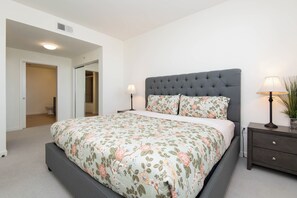 A bedroom with a large bed, two bedside tables, and a nightstand.
