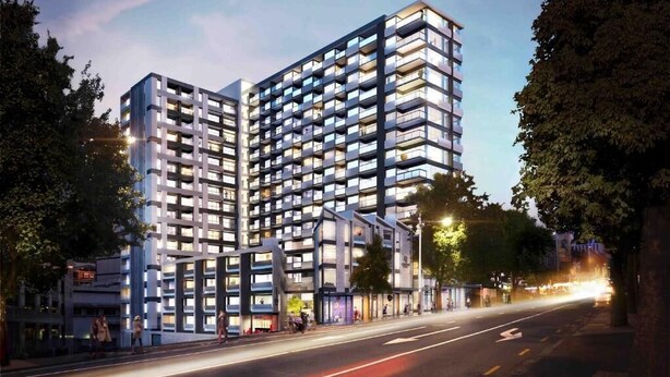 A modern multi-story building with balconies, a street view, and trees. - Central Haven Studio on Queen Street  (Auckland)