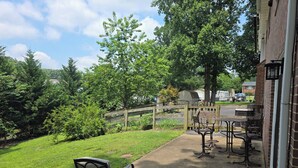 Eine Terrasse mit Gartenmöbeln, einem kleinen Tisch und einem Stuhl.