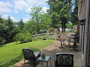 A patio with outdoor furniture, a small table, and a chair. - Comfy Mechanicsville rancher with entertainment for all age groups! (Mechanicsville)