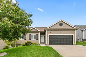 A residential house with a garage, a well-maintained lawn, and a large tree. - 4br 3ba Ranch West Omaha Game Room Near splash prk (Omaha)