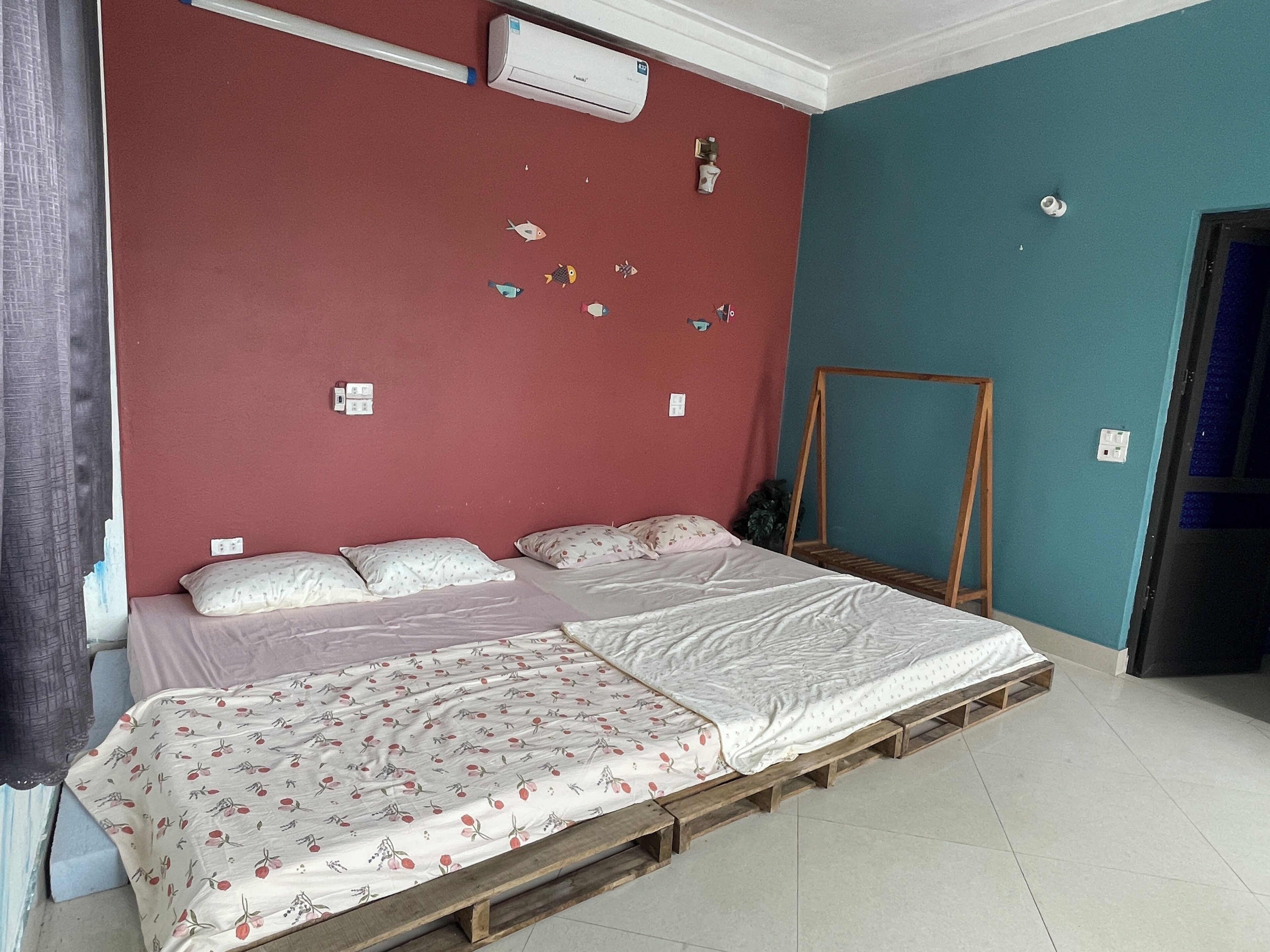 Una habitación con una cama, una escalera de madera y un aire acondicionado de pared.