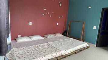 Una habitación con una cama, una escalera de madera y un aire acondicionado de pared.