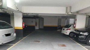 A parking garage with two cars parked, fire extinguishers, and a concrete floor. - Fairs and Shopping 202 (Vila Maria Alta São Paulo)