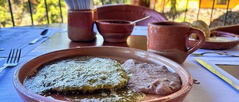 A meal on a table with a plate, a cup, and a spoon.