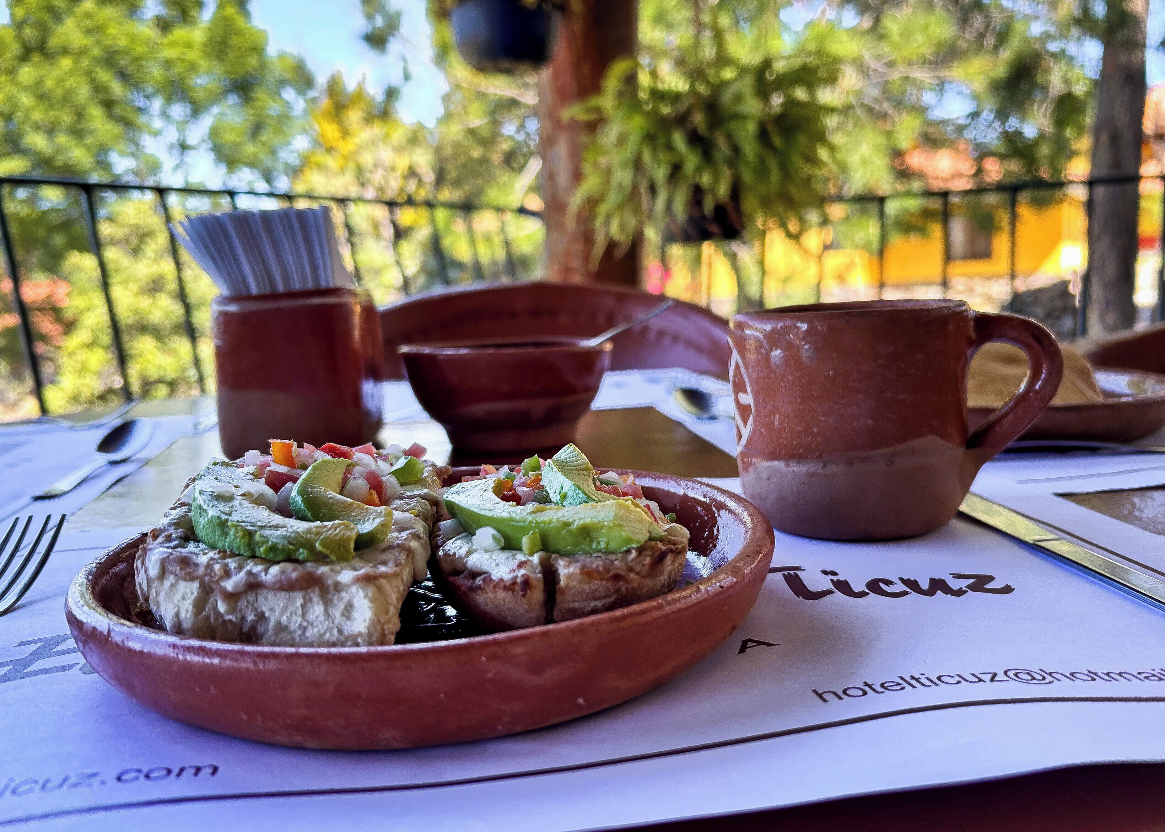 Un tavolo con un piatto di cibo, una tazza e un cucchiaio.