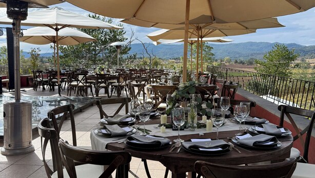 An outdoor dining area with round tables, beige umbrellas, and chairs. - El Mesón del Ticúz Tapalpa (Tapalpa)
