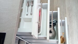 A modern kitchen with white cabinetry, a built-in oven, and a stainless steel sink.