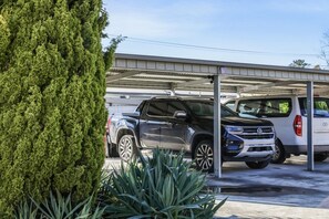 Un garaje con varios vehículos, incluyendo SUVs y una furgoneta.