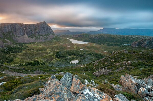 A mountainous landscape with a lake, rocky terrain, and sparse vegetation. - Stylish and Spacious Launceston Villa + Free Wifi (Launceston)