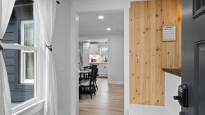 Un pasillo que conduce a un comedor con una pared de acento de madera y una guía de símbolos de lavandería.