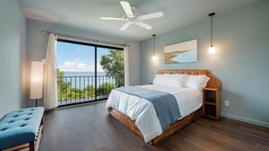 Un dormitorio con una cama grande, ventilador de techo, vistas al exterior y un balcón.