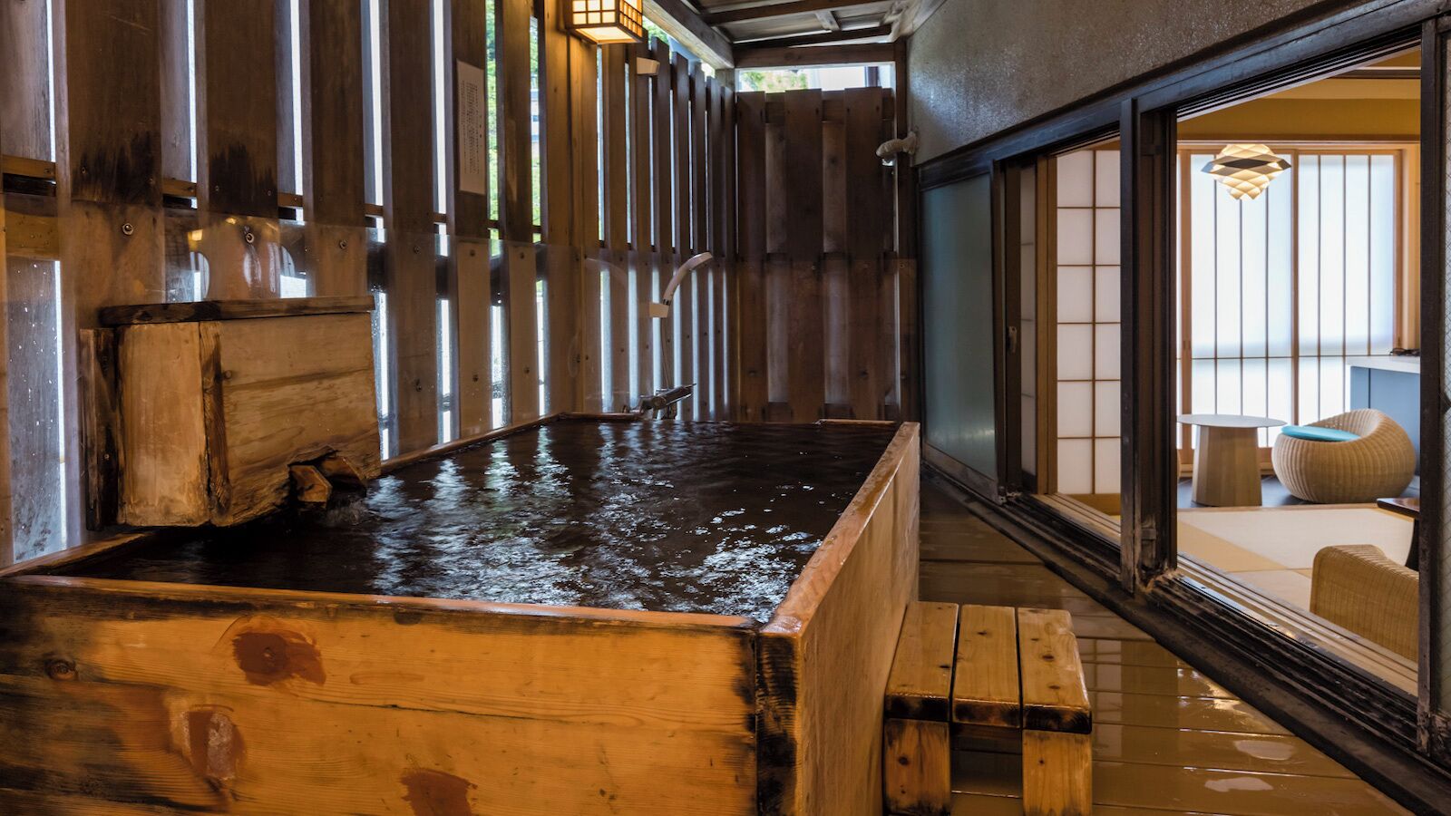 A traditional Japanese onsen with wooden benches and a wooden bath.
