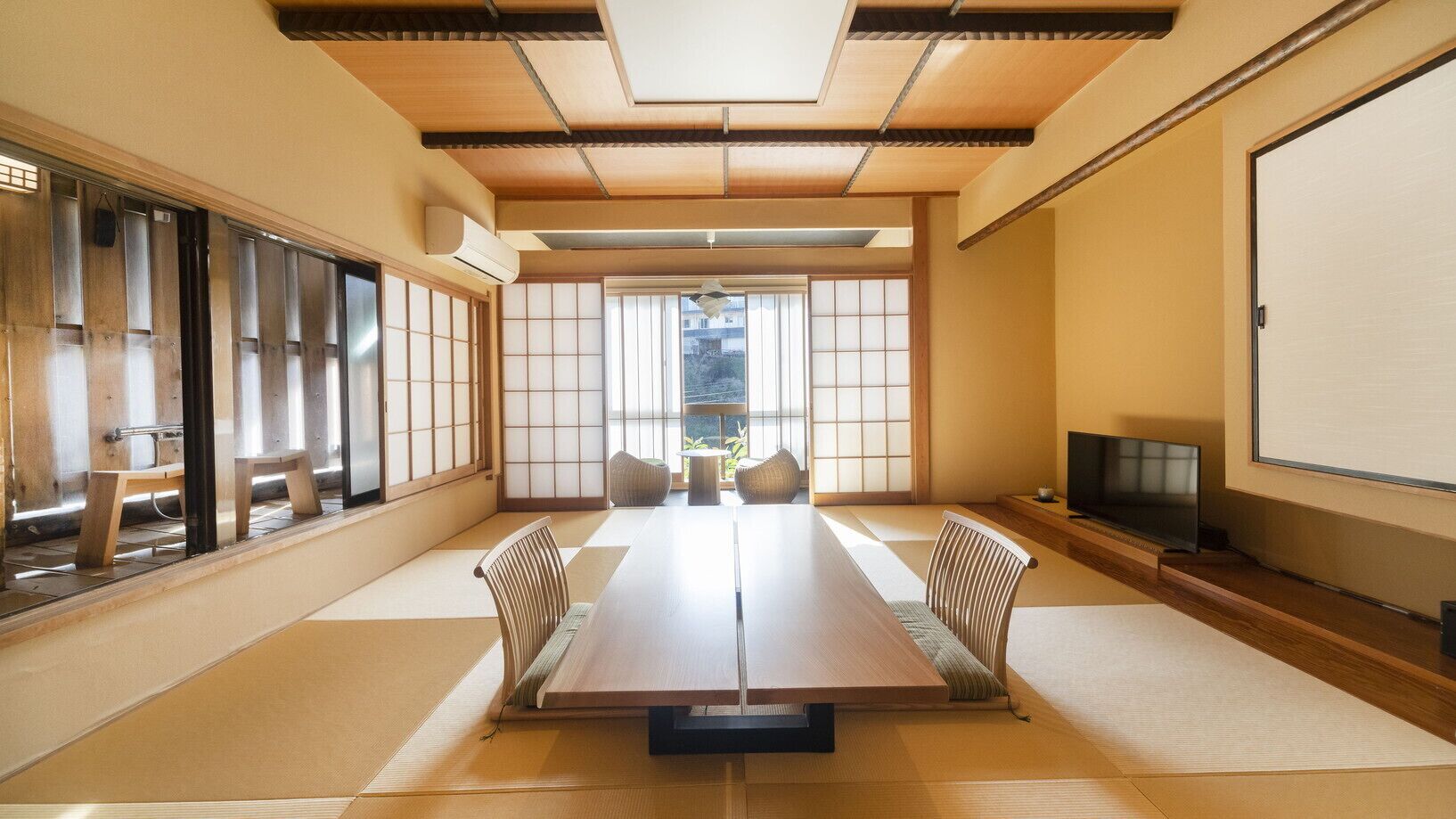 A traditional Japanese room with tatami flooring, a low table, and sliding doors.