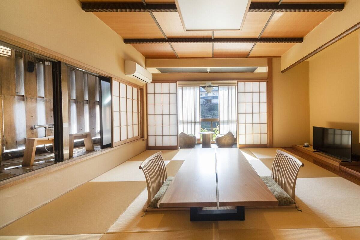 A traditional Japanese room with tatami flooring, a low table, and sliding doors.