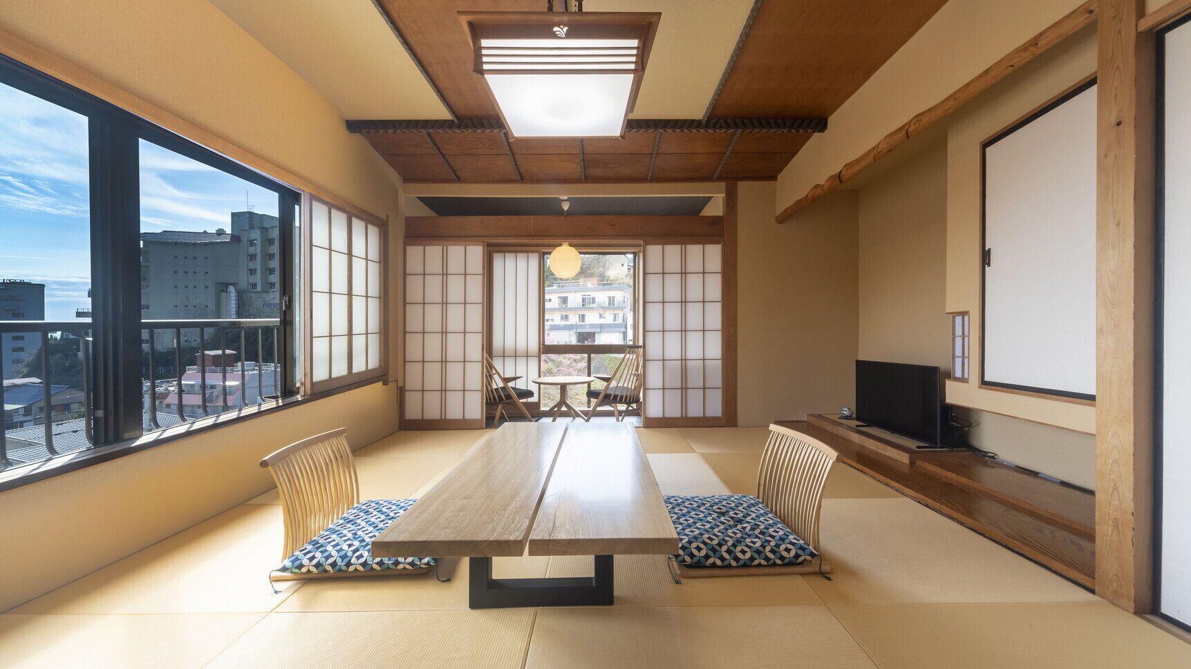 A traditional Japanese-style room with tatami flooring, a low table, and shoji screens.