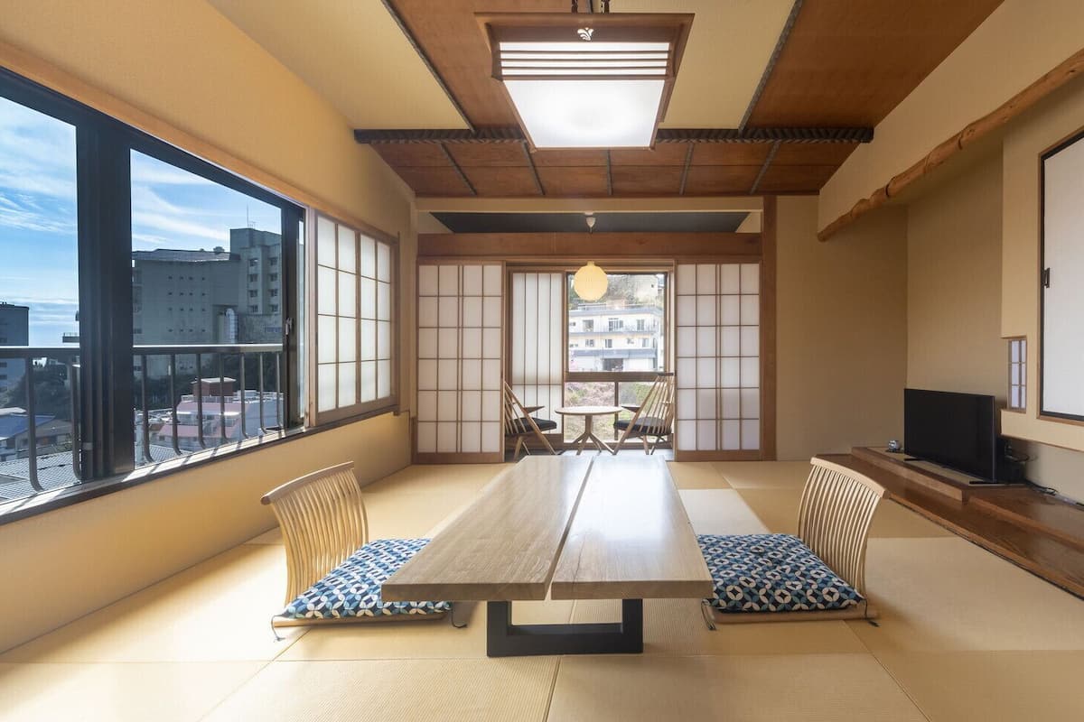 A traditional Japanese-style room with tatami flooring, a low table, and shoji screens.