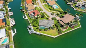 An aerial view of a residential area with a large house featuring a swimming pool, surrounded by water and greenery. - Waterfront, Private Pool, Walk to Tigertail Beach, Best of Marco! (Marco Island)