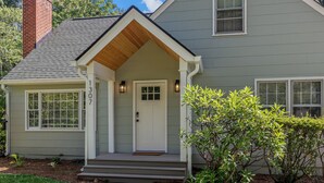 A two-story house with a front porch, a chimney, and a mailbox.
