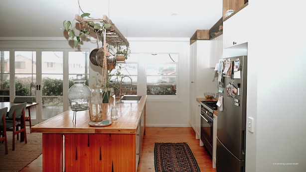 A modern kitchen with a wooden island, stainless steel appliances, and large windows. - Evans Head Beach House - Entertainer (Evans Head)