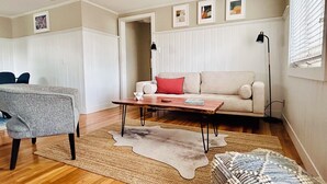 Un salon avec un canapé, une table basse, un tapis et un fauteuil.