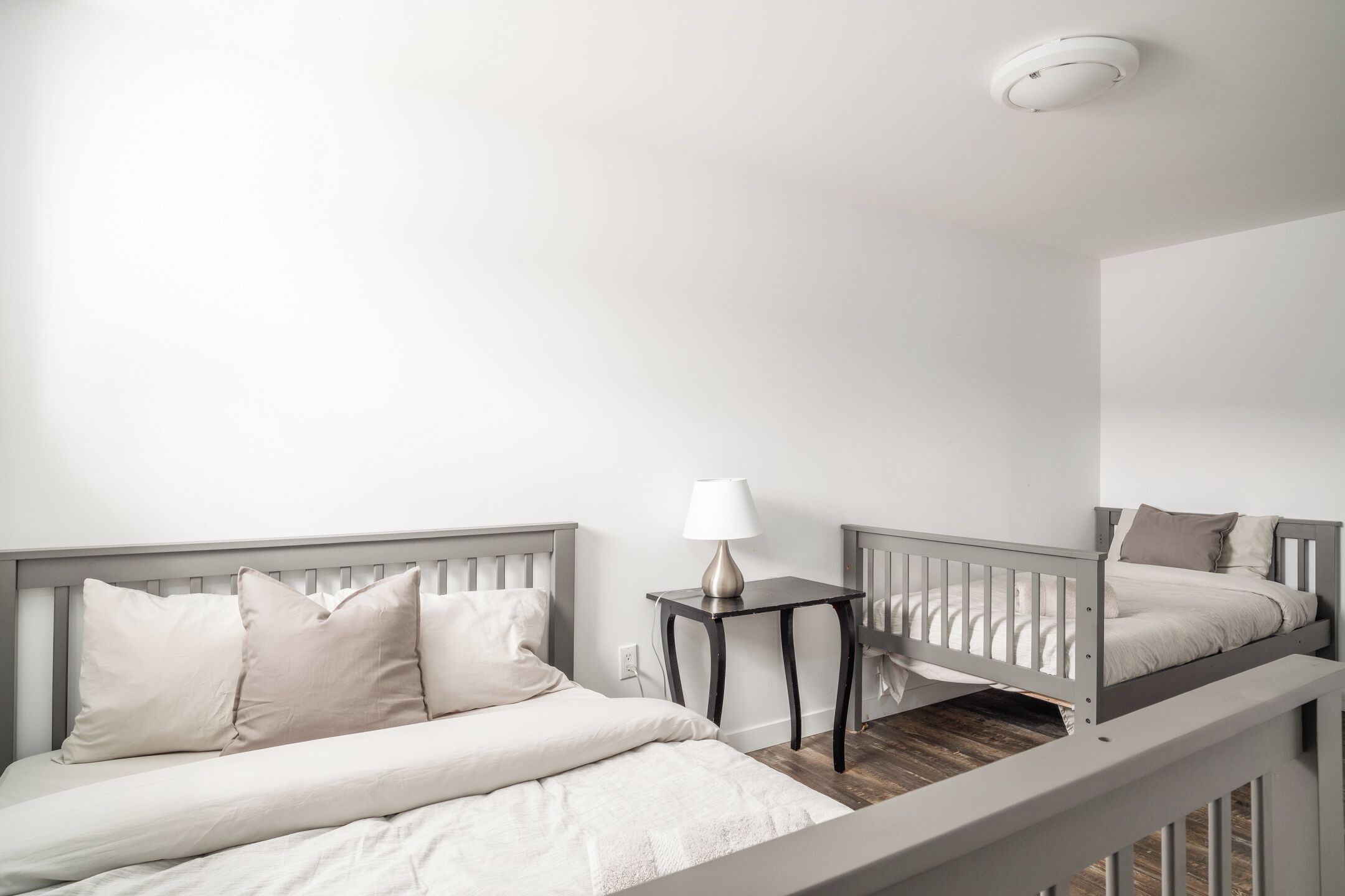A bedroom with a bed, a nightstand, a lamp, and a mirror.