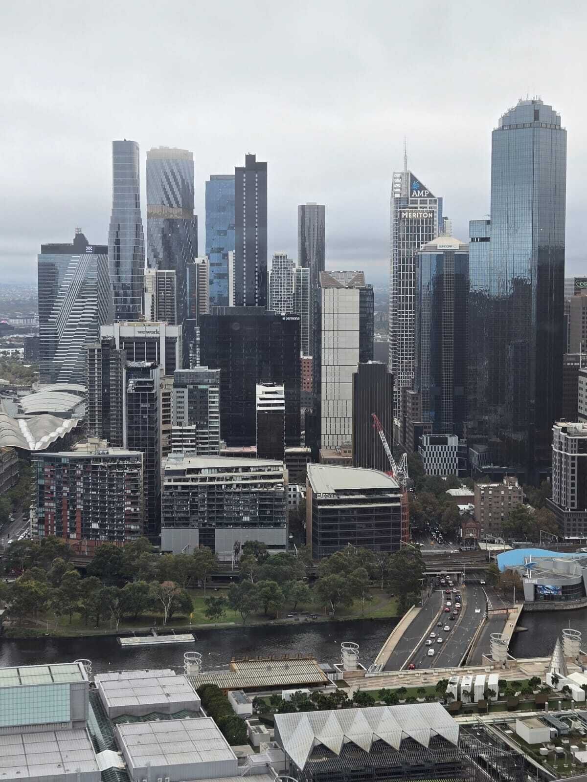 A cityscape with modern skyscrapers, a river, and a bridge.
