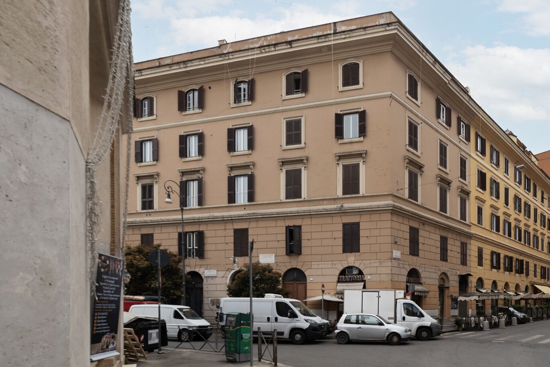 A multi-story building with a classical architectural style, featuring evenly spaced windows and a symmetrical facade.