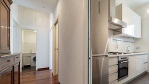 Una cocina moderna con electrodomésticos de acero inoxidable, horno empotrado y campana extractora.