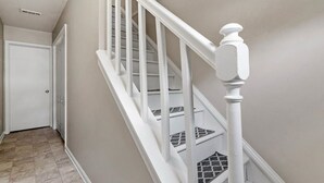A staircase with white railings and a white door at the top. - North Hills/Gym/Sauna/Massage Chair/Pool (Raleigh)