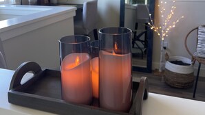 A modern kitchen with a white countertop, a black tray holding three candles, and a window with a view of greenery. - 7 min to downtown! Retreat for 2 on Queen Anne Hill w/Rooftop Deck & Ocean View. (Seattle)