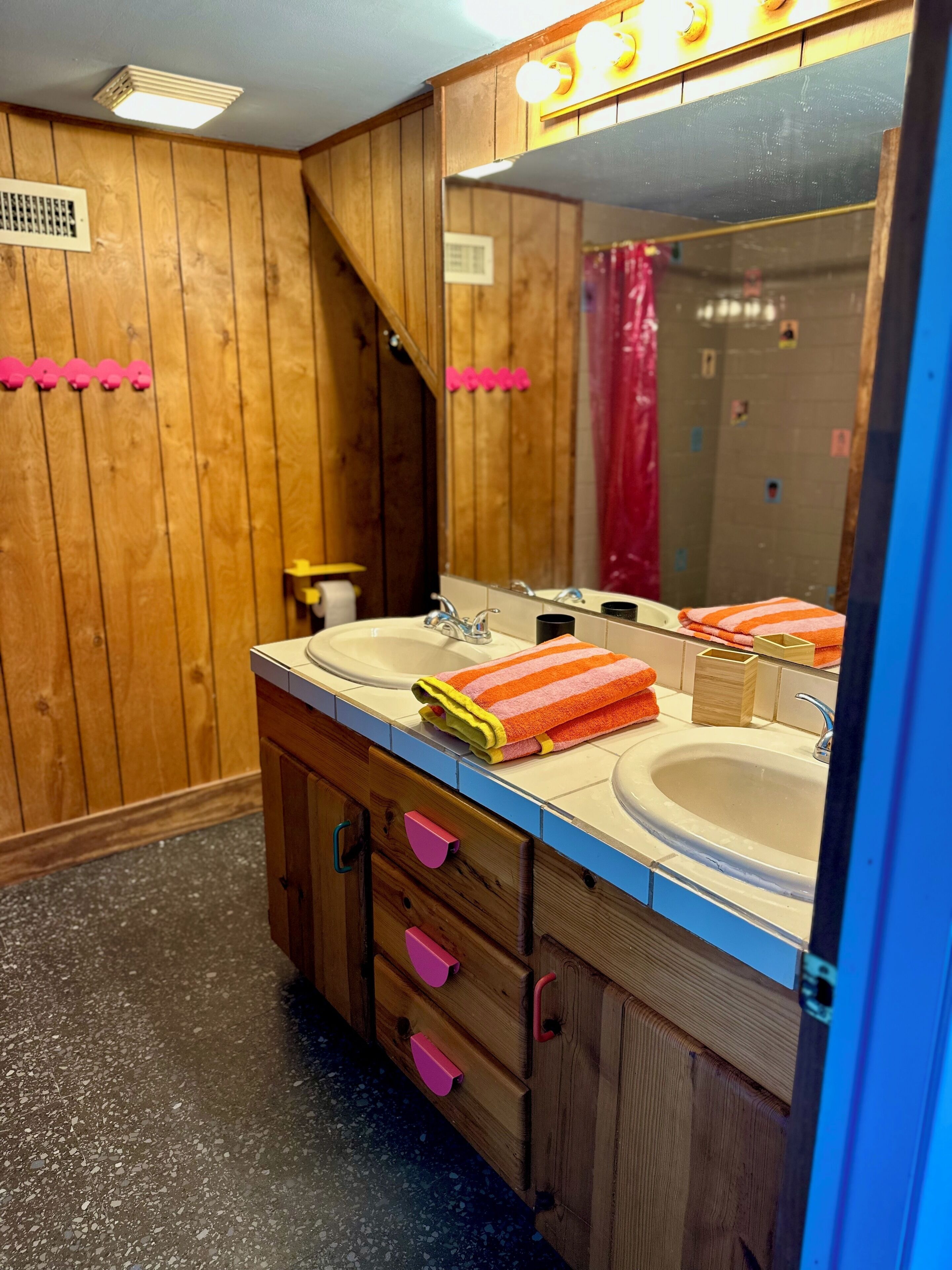 Une salle de bain en bois avec deux lavabos, un miroir et un espace douche.