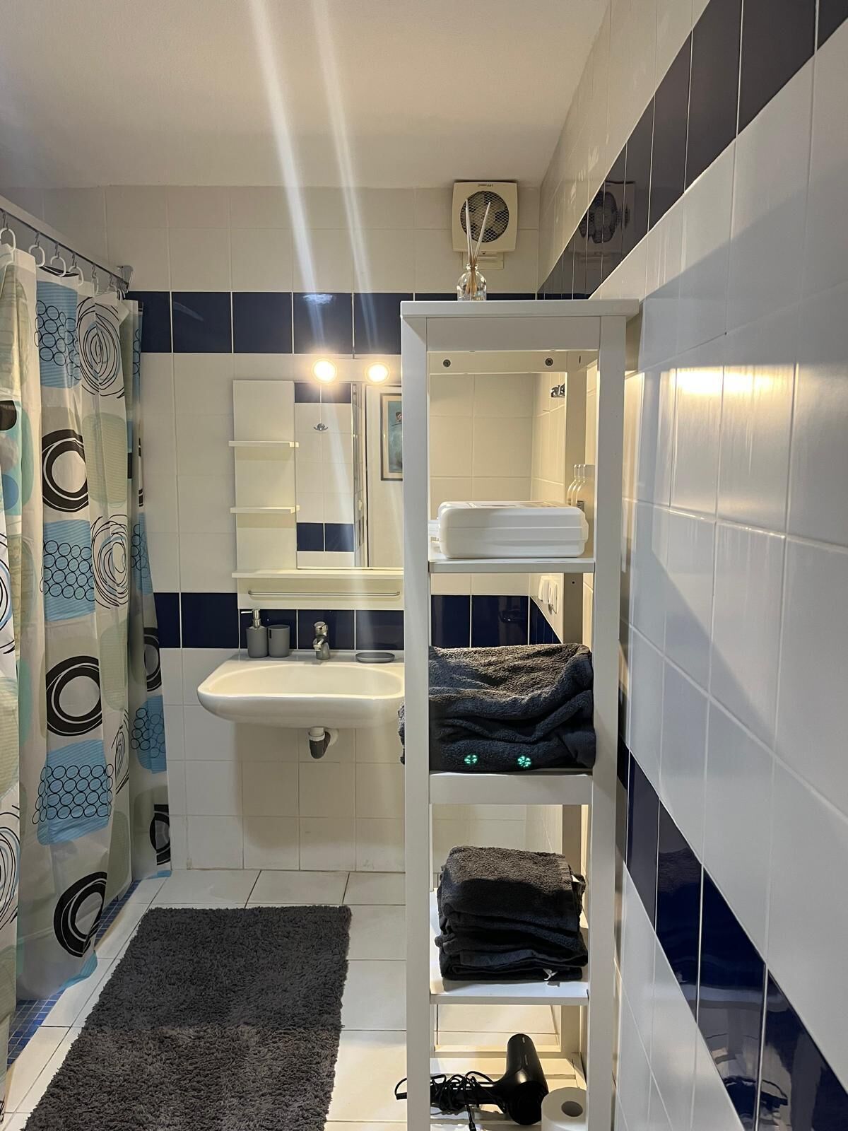 A bathroom with a white sink, mirror, and towel rack.