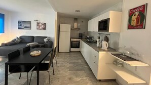 A modern apartment with a kitchen, dining area, and living room.