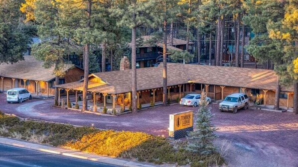 A lodge with a covered patio, multiple guest rooms, and a sign indicating 'Timber Lodge'. - Timber Lodge (Pinetop-Lakeside)