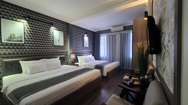 A hotel room with two beds, a TV mounted on the wall, and a large window with curtains. - Hanoi Lucky Hotel (Hanoi)
