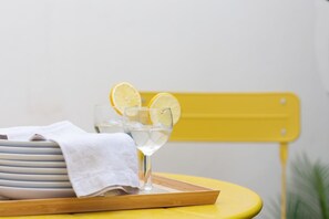 A yellow chair with a white towel and a tray holding two glasses of water with lemon slices. - VLC HOST - Fray Pedro B (Valencia)