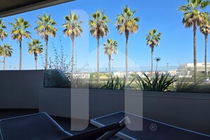 A balcony with a view of palm trees and a clear sky.