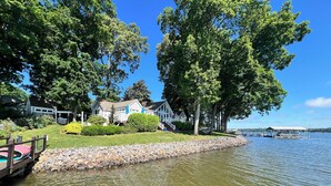 Une propriété au bord du lac, dotée d’un quai, d’une piscine et d’un mur en pierre.
