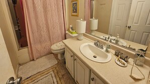A bathroom with a toilet, sink, and shower curtain. - 3-bedroom house in delightful S Raleigh WiFi, AC (Raleigh)
