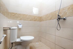 A small, modern bathroom with a toilet, bidet, and shower. - Villa Normandie (Cimahi)
