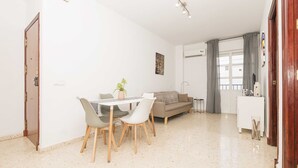 Een moderne woonkamer met een eetgedeelte, een bank, een salontafel en een bijzettafeltje.
