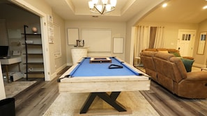Relax and work in style with a pool table, comfortable seating, and a dedicated workspace.
