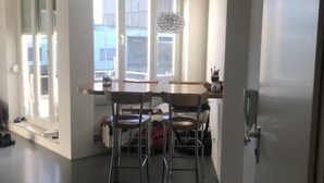 A kitchen with a dining table, chairs, and a window with blinds. - Apartment 'Bechtel' with Balcony and Wi-Fi (Langenargen)