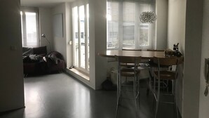 A modern kitchen with a dining table, chairs, and a pendant light. - Apartment 'Bechtel' with Balcony and Wi-Fi (Langenargen)