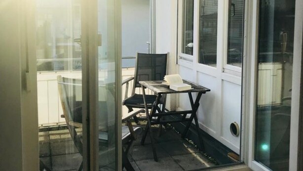 A small room with a single table and chair, a window, and a door. - Apartment 'Bechtel' with Balcony and Wi-Fi (Langenargen)