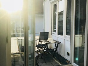 Une petite pièce avec une seule table et une seule chaise, une fenêtre et une porte.