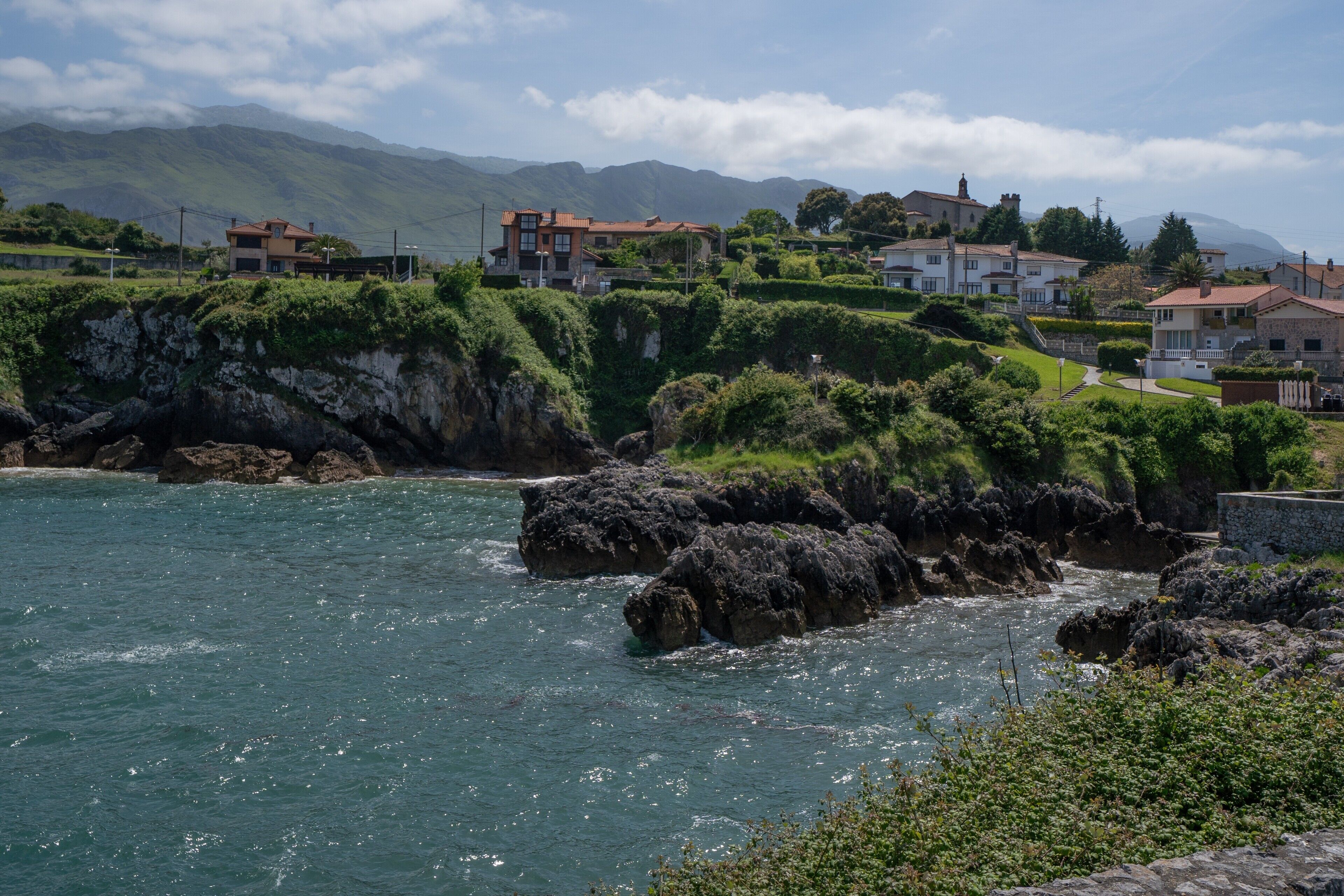 Un pueblo costero con casas en una colina con vistas al mar.