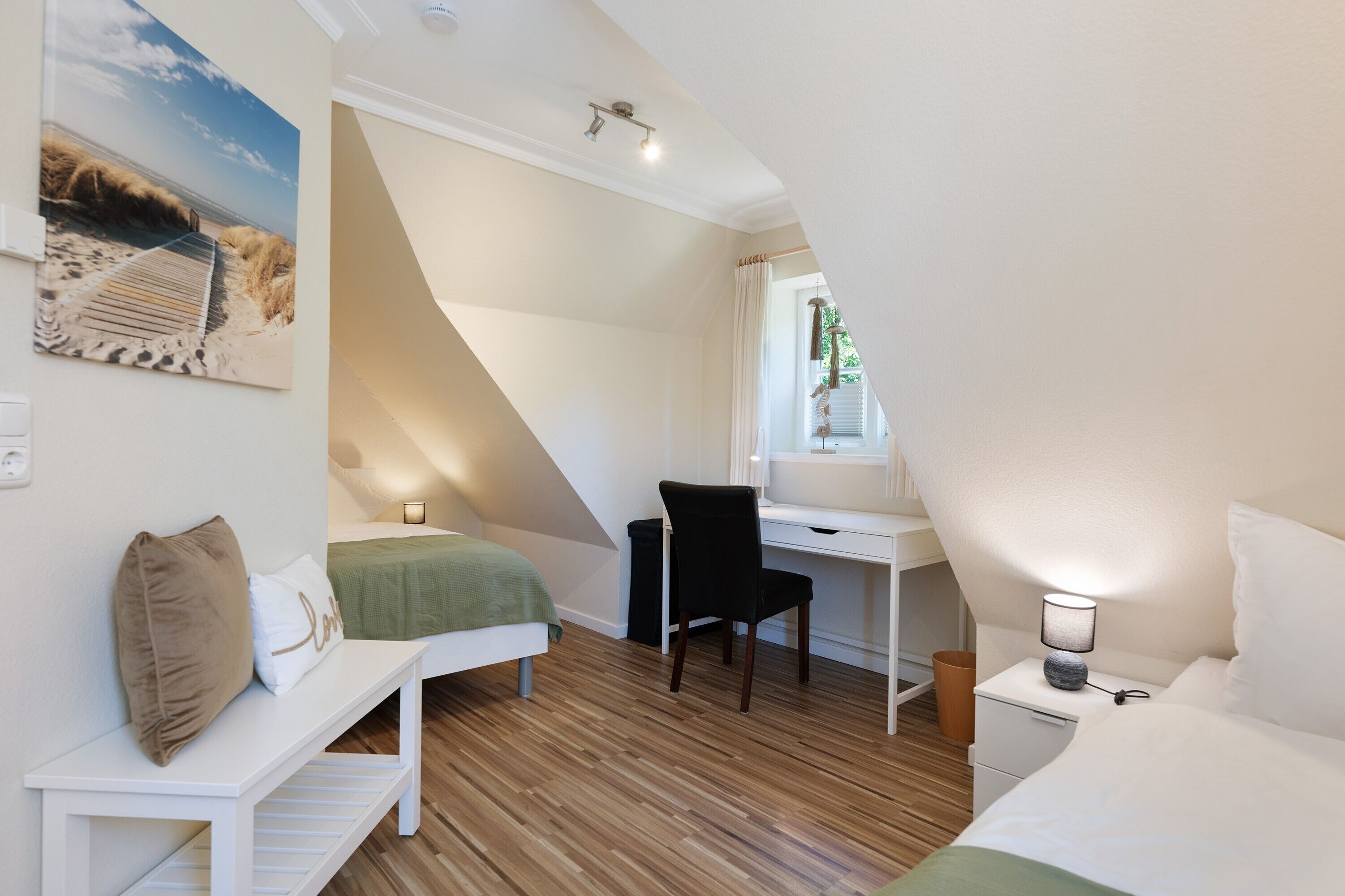 A bedroom with a bed, a desk, a chair, a bench, and a painting on the wall.