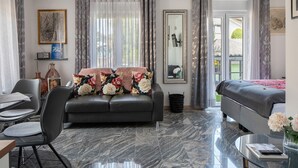A modern living room with a sofa, a dining table, and a coffee table.